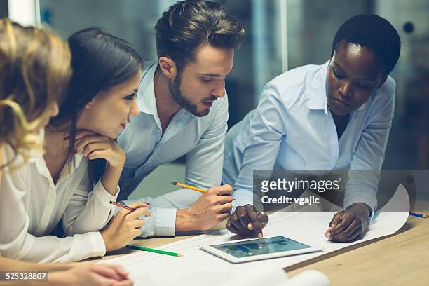 multiethnic team of architects reviewing reports in the office. - motion study stock pictures, royalty-free photos & images