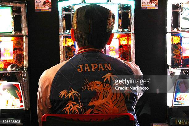Japanese man plays pachinko slot machine a Japanese form of legal gambling in Tokyo December 27, 2014.
