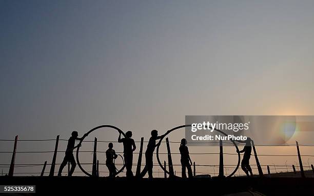 Indian elctricians roll cables on temporary pantoon bridge over Ganges river, ahead of Magh mela festival,in Allahabad on January 6,2016.The Magh...