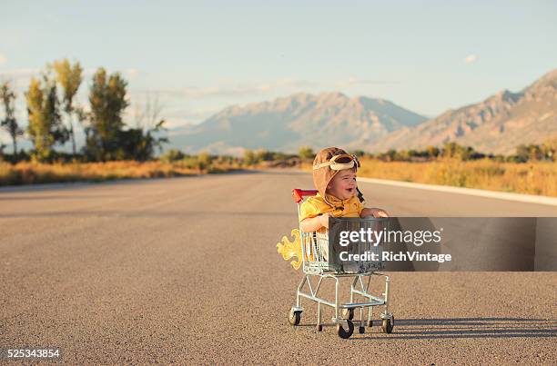 little toddler boy sitting in shopping cart - aviation hat 個照片及圖片檔