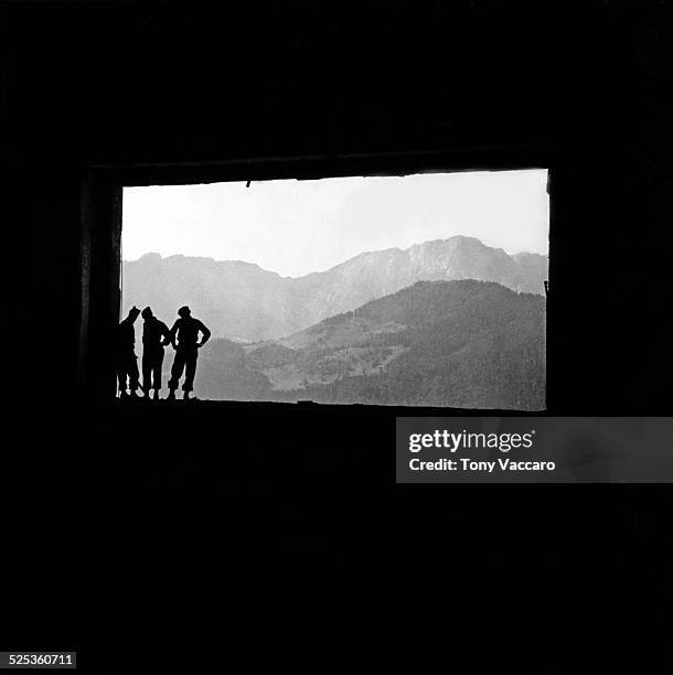 GIs in silhouette can be seen standing in the ruins of Hitler's mountain retreat, the Berghof, Obersalzberg, Germany, World War II, June 1945.