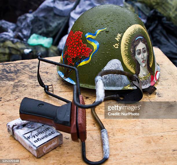 Cigarettes, a sling and a protester's helmet with St. Michael picture on it.