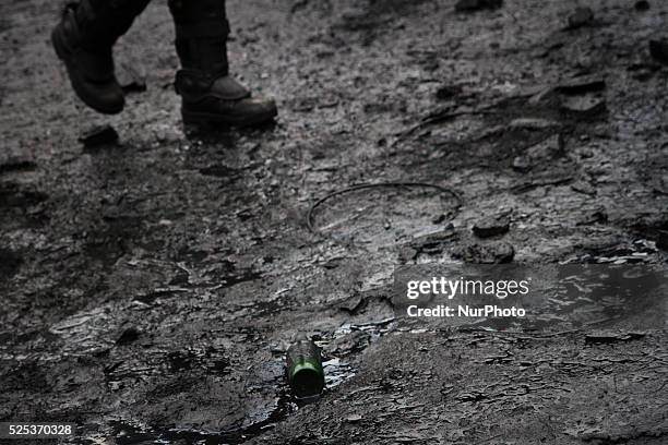 People pass the brook flowing from the barricades built of bags with snow