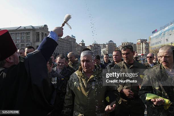 Chaplain blesses flags and standards and sprinkles soldiers with holy water. Ukraine marks the first anniversary of the first volunteering General...