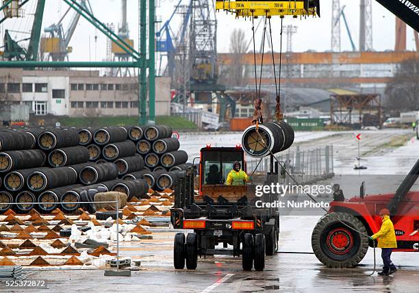 Workers arrange pipes delivered for construction of the South Stream gas pipeline and load them on a ship for unknown direction at the Black sea...