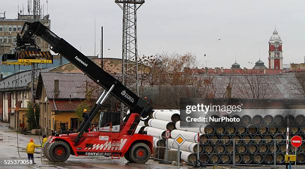 Workers arrange pipes delivered for construction of the South Stream gas pipeline and load them on a ship for unknown direction at the Black sea...