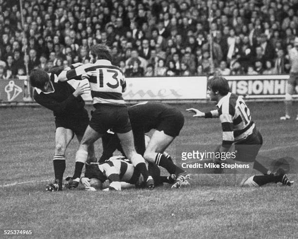 The New Zealand national rugby union team, the All Blacks during a match against Wales in Cardiff, 4th November 1972. Here Cardiff's Keith James ,...