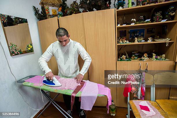 Boy with intellectual disability ironing textile for applique in working class, Teterivka's Orphanage and Boarding school. Zhytomyr, Ukraine. 2 of...