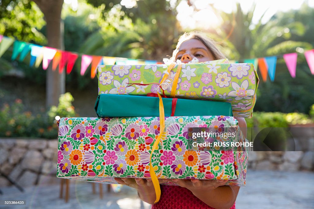 Girl carrying pile of birthday presents