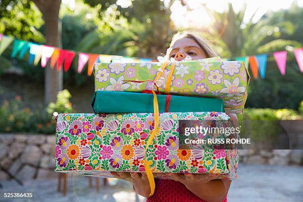 girl carrying pile of birthday presents - birthday gift stock pictures, royalty-free photos & images