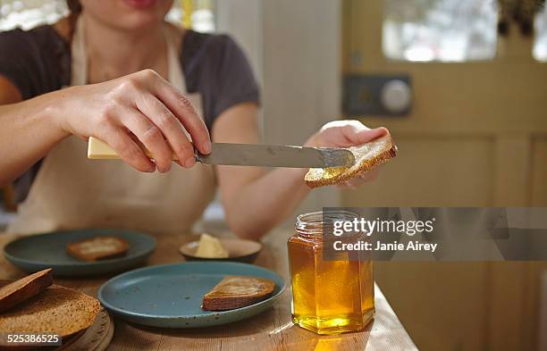woman tasting freshly extracted honey on bread - honey stock pictures, royalty-free photos & images