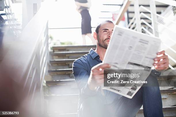 businessman reading newspapers on staircase - holding paper fotografías e imágenes de stock