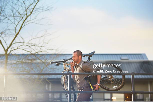 businessman running with bicycle and folder in arms - carrying bike stock pictures, royalty-free photos & images