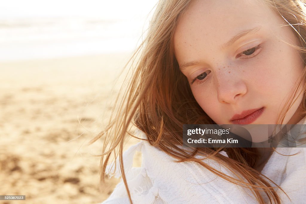 Close up portrait of girl wrapped in blanket on beach