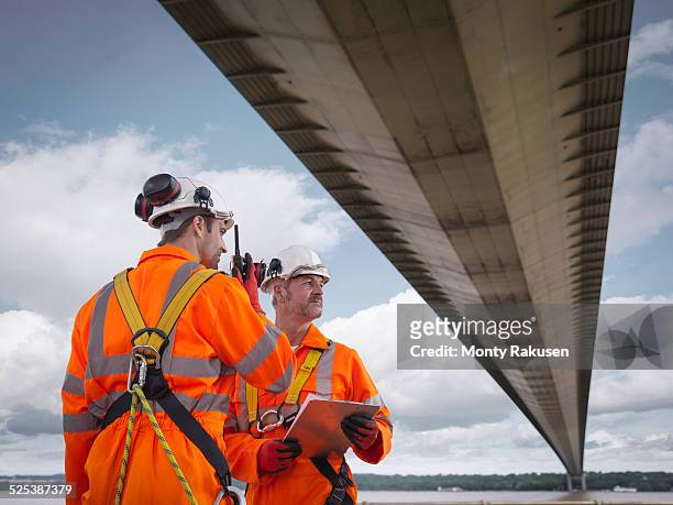 bridge workers using walkie-talkie under suspension bridge. the humber bridge, uk was built in 1981 and at the time was the worlds largest single-span suspension bridge - humber bridge stock pictures, royalty-free photos & images