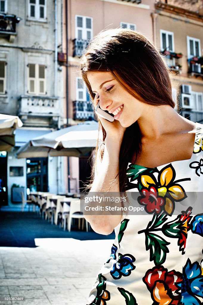 Young woman chatting on smartphone on street, Cagliari, Sardinia, Italy