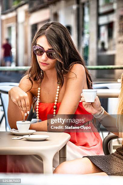 two young female friends drinking espresso at sidewalk cafe, cagliari, sardinia, italy - fancy coffee drink stock pictures, royalty-free photos & images