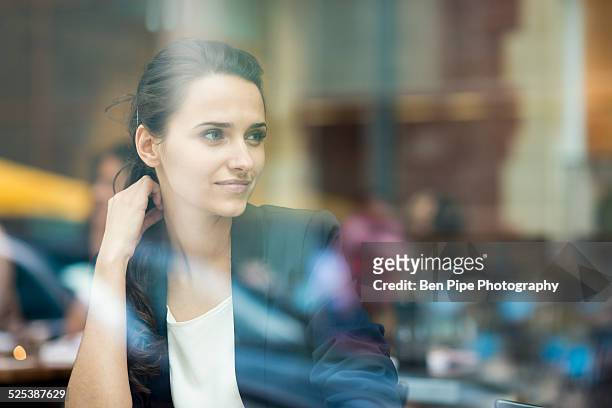 young businesswoman looking out of cafe window, london, uk - businesswoman in suit jackets stock-fotos und bilder