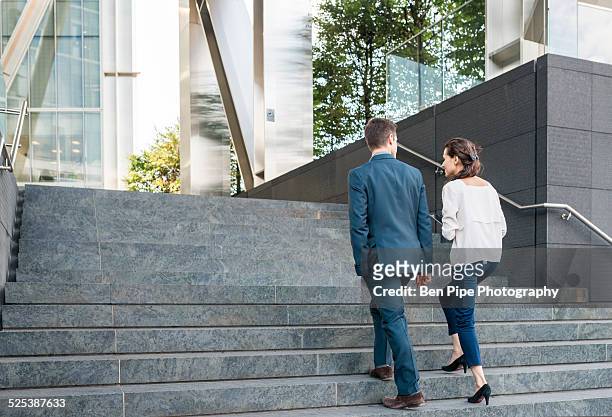 rear view of young businessman and woman walking up stairway, london, uk - 階段　のぼる ストックフォトと画像