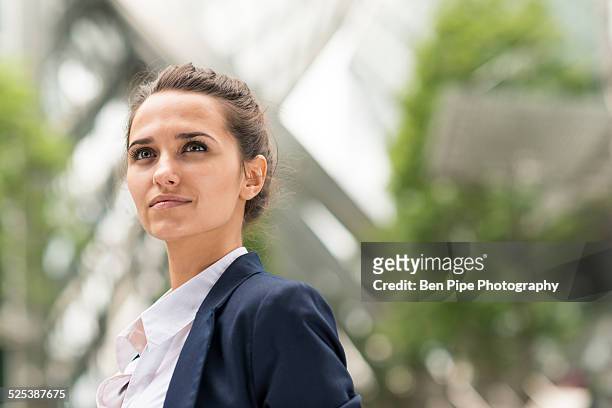 confident young businesswoman at broadgate tower, london, uk - woman looking up sideview stock-fotos und bilder