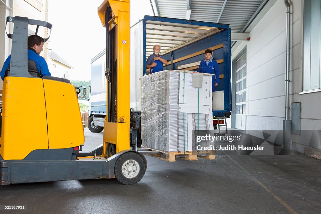 Factory worker operating forklift