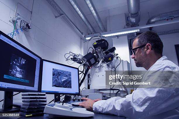 lab assistant working with sem image on computer - microscopio electrónico fotografías e imágenes de stock