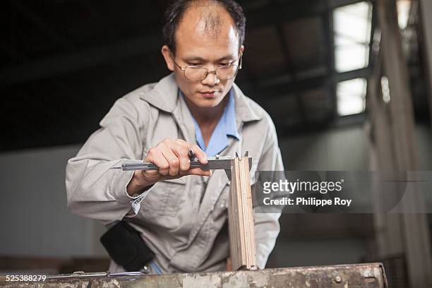 carpenter measuring wood plank with vernier caliper in factory, jiangsu, china - vernier caliper stock-fotos und bilder