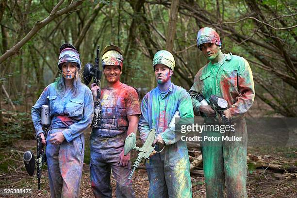 paintball players in paintball wear marked with paint - paintball stock pictures, royalty-free photos & images