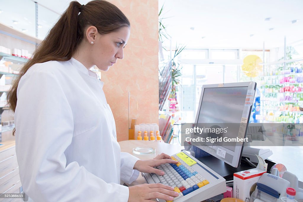 Pharmacist in pharmacy using computer