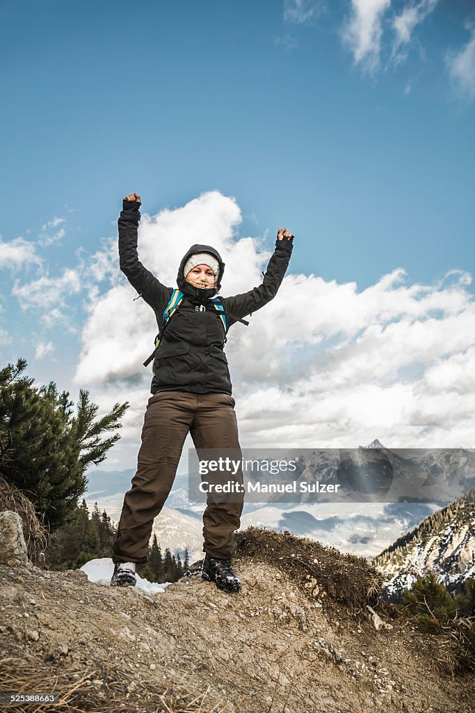 Young woman celebrating on mountain ridge, Hundsarschjoch, Vils, Bavaria, Germany