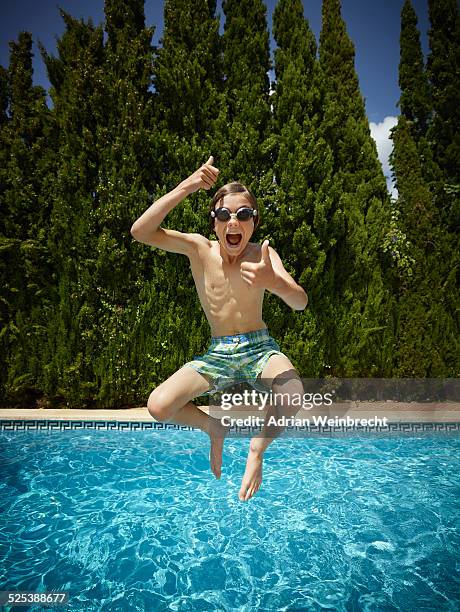 boy jumping into swimming pool, majorca, spain - kid jumping into swimming pool stock pictures, royalty-free photos & images