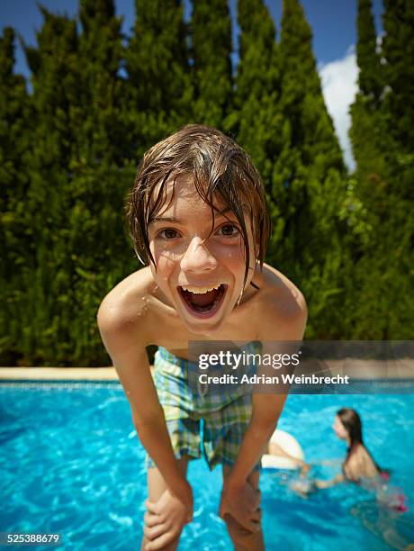 portrait of boy leaning forward in front of swimming pool, majorca, spain - wide angle stock-fotos und bilder