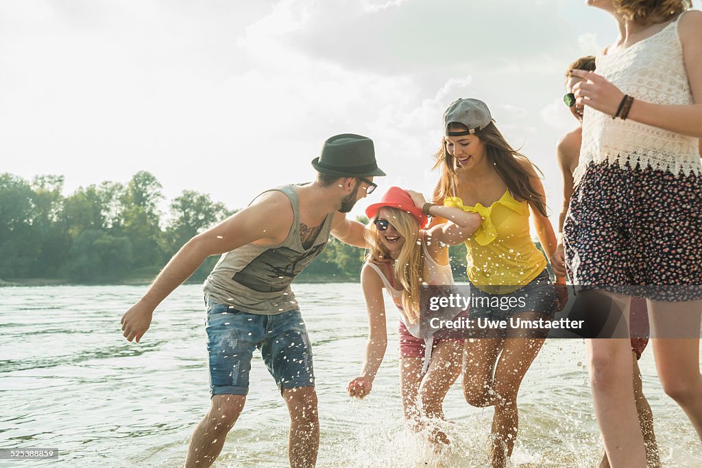 Group of young friends running in lake