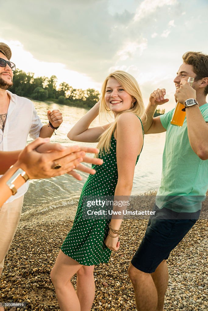 Group of friends dancing on beach