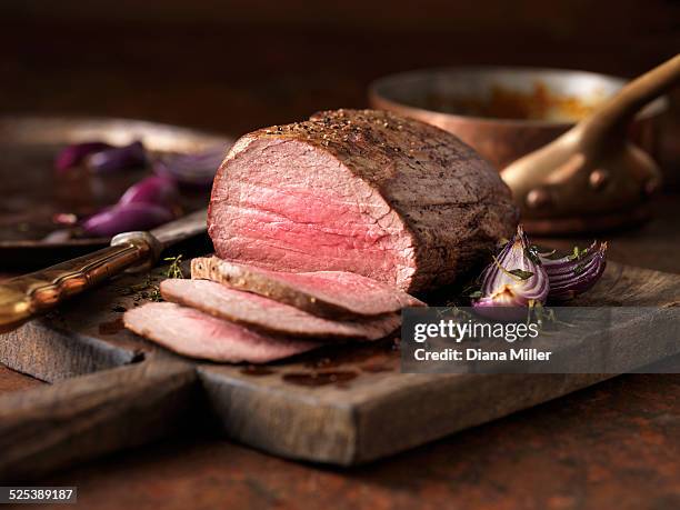 christmas dinner. chateaubriand steak cooked with a thick cut from the tenderloin filet, rare medium served with roasted onions, pepper and herbs - fleisch stock-fotos und bilder