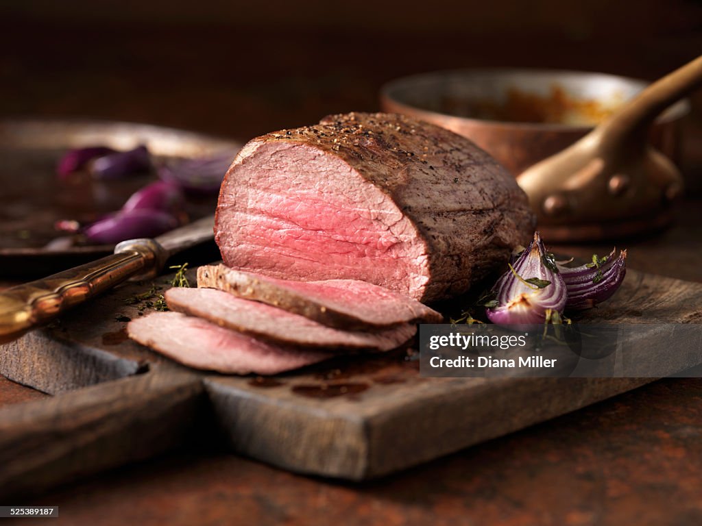 Christmas dinner. Chateaubriand steak cooked with a thick cut from the tenderloin filet, rare medium served with roasted onions, pepper and herbs