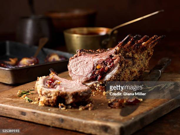 christmas dinner. lamb rack rare medium with cranberry and clementine stuffing and rosemary - lammbraten stock-fotos und bilder