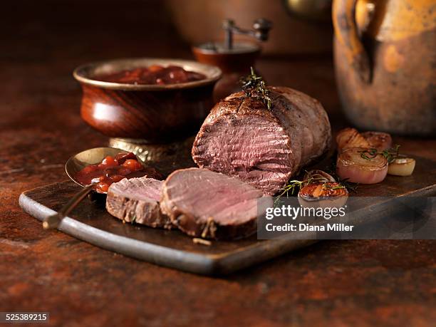 christmas dinner. venison rump with mulled winter fruit sauce and red onions - wildbret stock-fotos und bilder