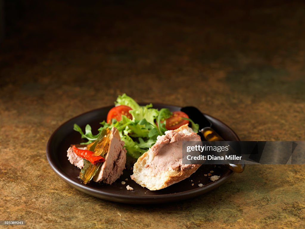 Christmas snack of Brussels pate with red chillies, rocket and mixed green lettuce leaves, cherry tomatoes