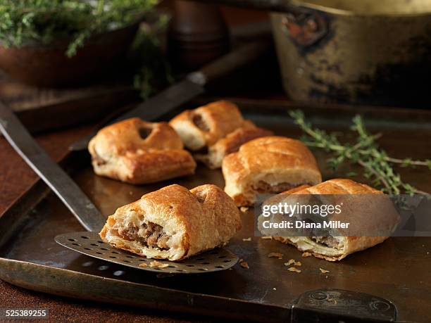 christmas snack of gourmet sausage rolls and thyme leaves - sausage roll stock-fotos und bilder