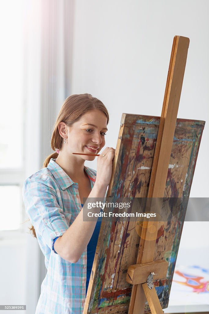 Female artist painting at easel