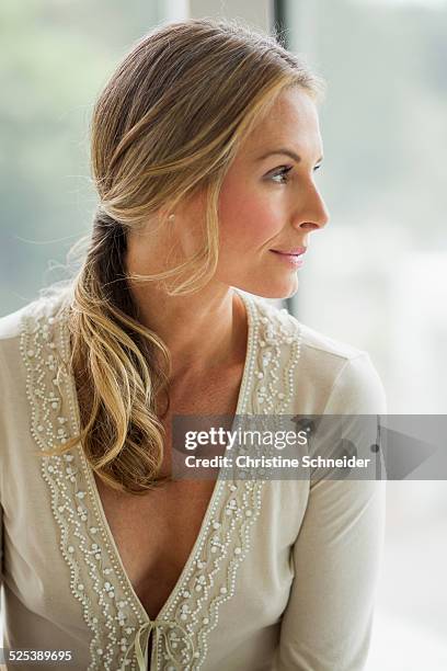 mature blonde woman looking away, portrait - dekolletage foto e immagini stock