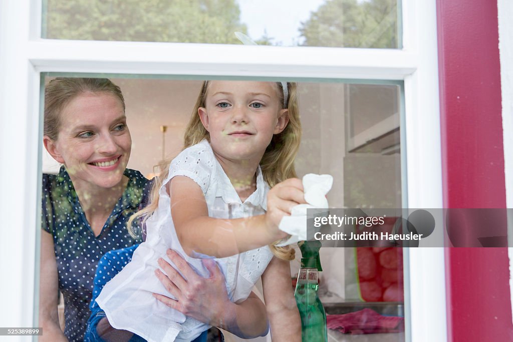 Mother and daughter cleaning window