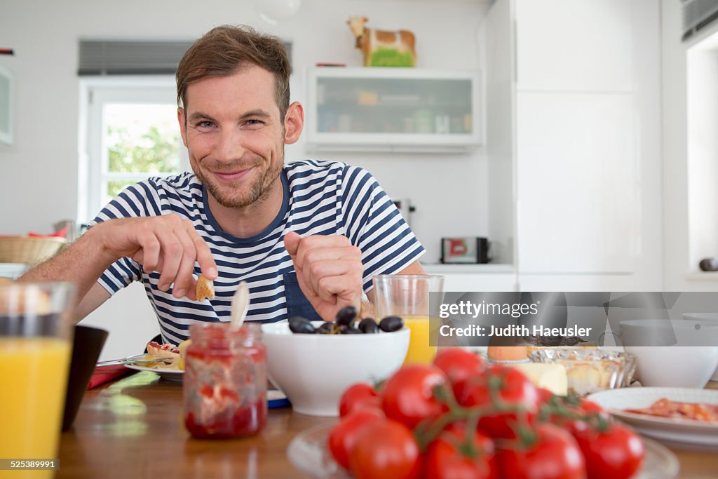 Mid adult man eating at kitchen table