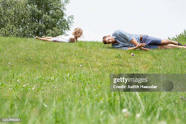 father and daughter rolling downhill - de rola imagens e fotografias de stock