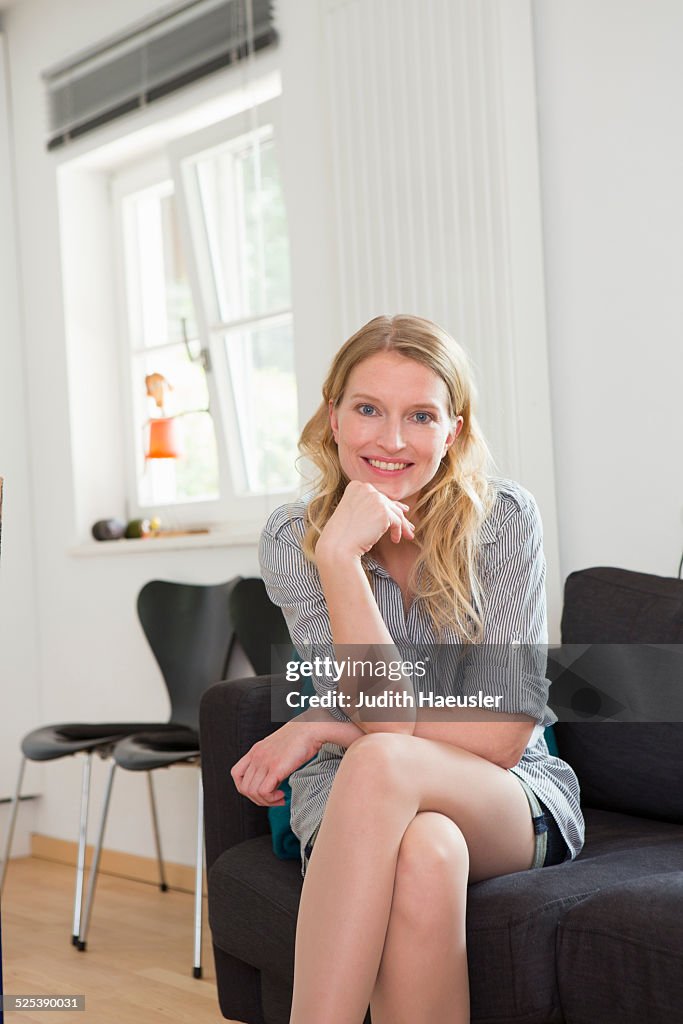 Mid adult woman sitting on sofa, portrait