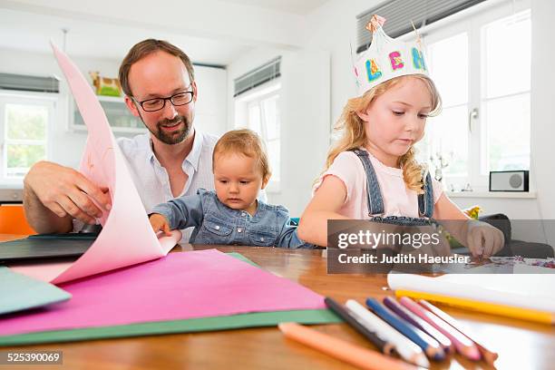 family making paper crowns - paper crown stock pictures, royalty-free photos & images