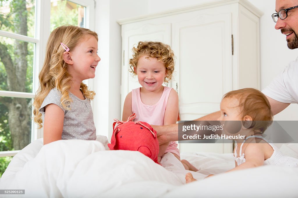 Three girls playing on bed