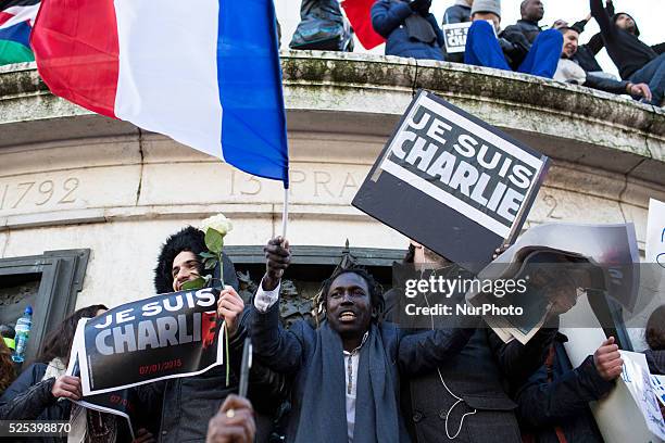 People holding cardboards reading &quot;Je suis Charlie take part in a Unity rally "Marche Republicaine" on the Place de la Republique in Paris on on...