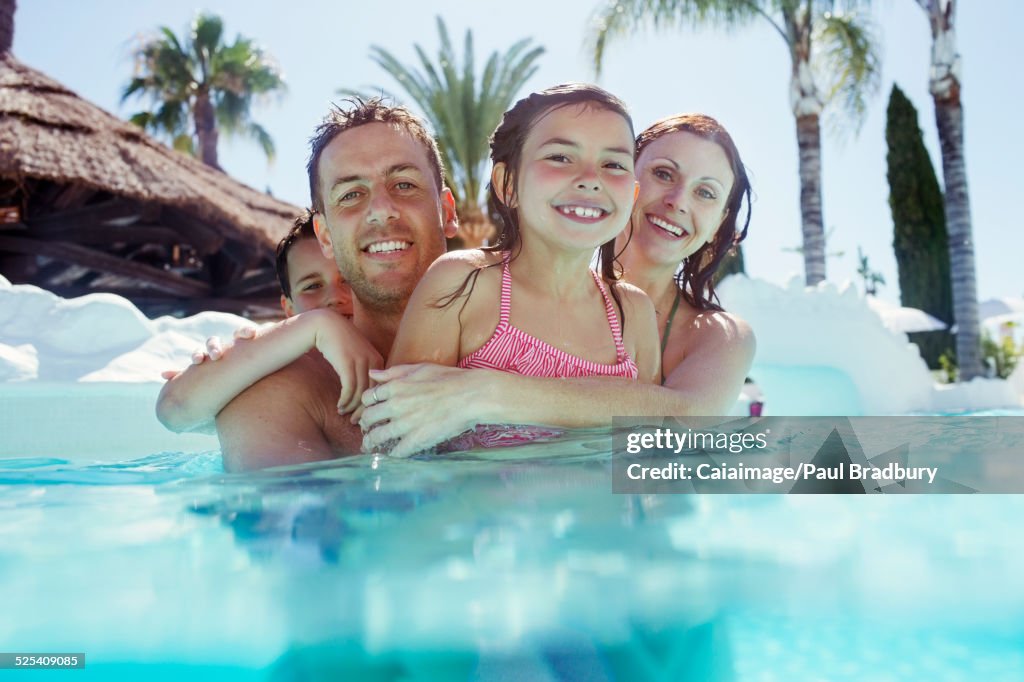 Portrait of happy family with son and daughter in swimming pool